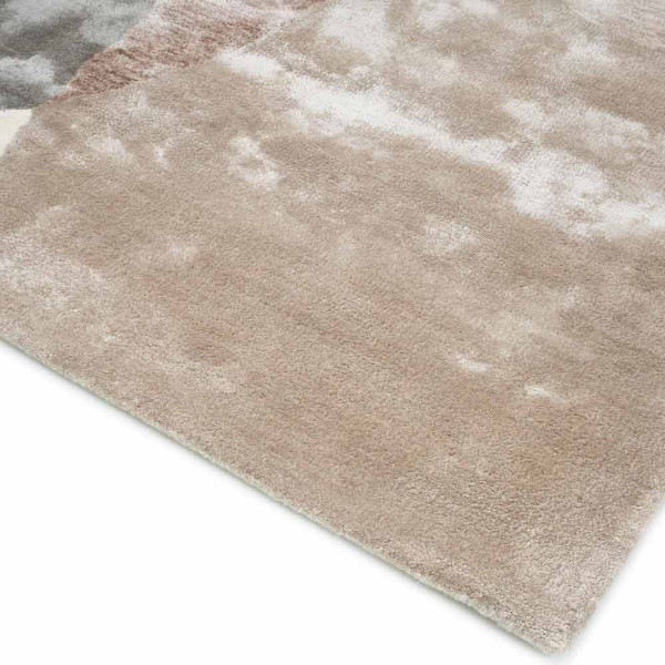 Moderner Teppich in Beige mit abgerundeten, organischen Formen in Grau, Braun und Beige. Der Teppich trägt den Namen Lagos und ist auf einem hellen Untergrund positioniert.