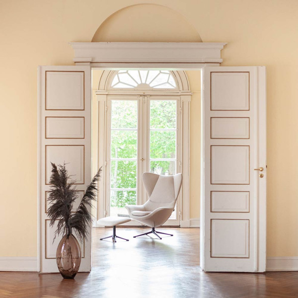 Beige Relaxsessel Stilo steht auf einem schmalen Metallfuß. Die geschwungene Form bietet Komfort und elegantes Design für Wohnzimmer oder Büros. Erhältlich für 1.119,00 €.