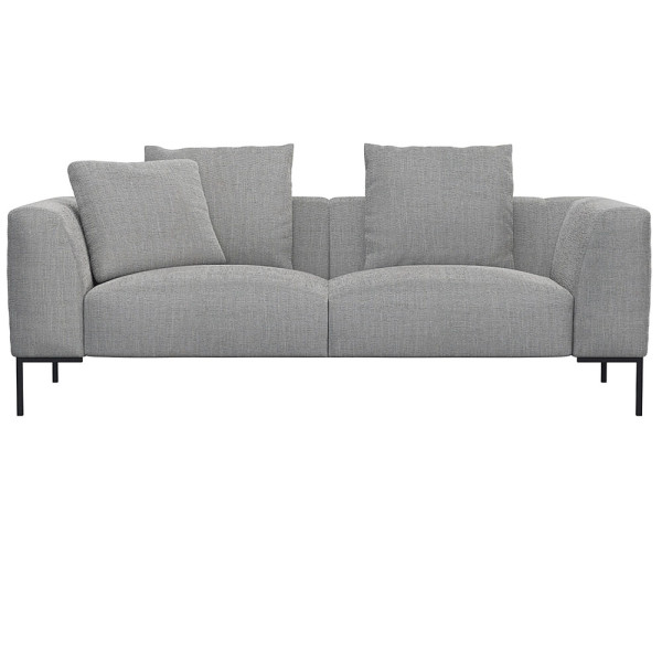 Helles, modernes Sofa in hellbeiger Farbe mit zwei Kissen. Es hat eine schlichte, rechteckige Form und steht auf schwarzen Beinen. Die Oberfläche wirkt einladend und bequem.