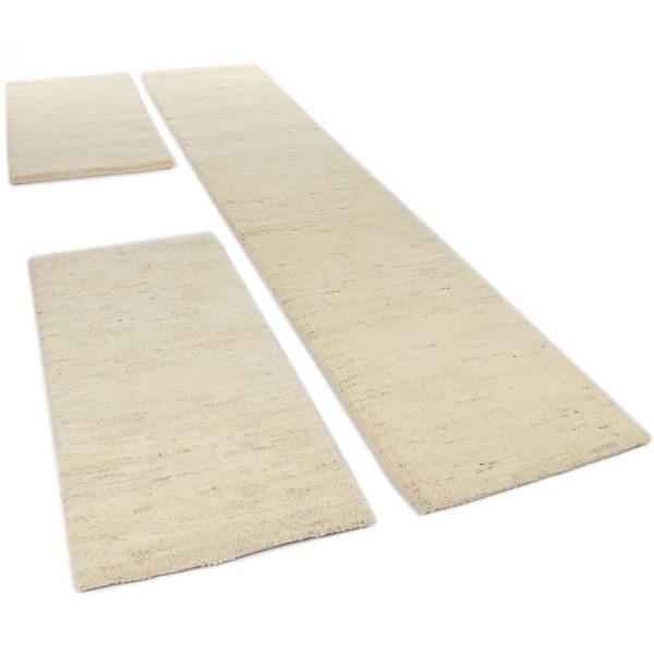 Drei Teppiche in hellem Beige sind angeordnet. Zwei kleine rechteckige Teppiche liegen oben und unten, während ein großer, länglicher Teppich in der Mitte positioniert ist.