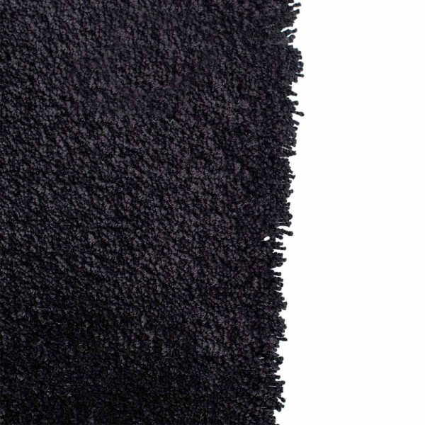 Schwarzer, weicher Webteppich aus Polyester mit fransigen Kanten. Der Teppich eignet sich für individuelle Maßanfertigungen und bietet eine vielseitige Gestaltungsmöglichkeit für verschiedene Räumlichkeiten.