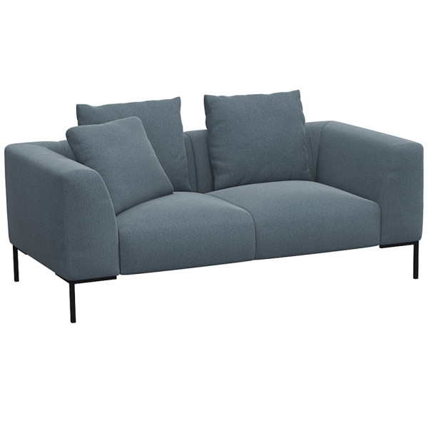 Helles, modernes Sofa in hellbeiger Farbe mit zwei Kissen. Es hat eine schlichte, rechteckige Form und steht auf schwarzen Beinen. Die Oberfläche wirkt einladend und bequem.