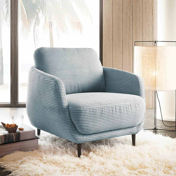 Moderner Cordsessel in hellblauer Farbe mit breiten Armlehnen und einem gepolsterten Sitz. Der Sessel hat schlanke Metallbeine in Schwarz und eine geschwungene Form.